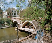 828223 Gezicht op de Vollersbrug te Utrecht, tijdens de restauratie, vanaf de oostzijde van de Oudegracht, met links de ...